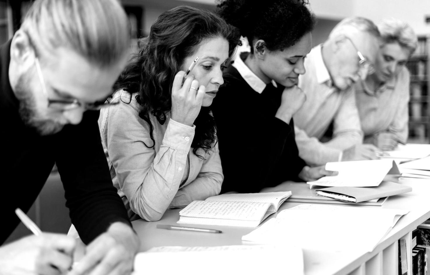 Gruppo di persone impegnate in una sessione di coaching collaborativo, sedute in cerchio in un ambiente accogliente